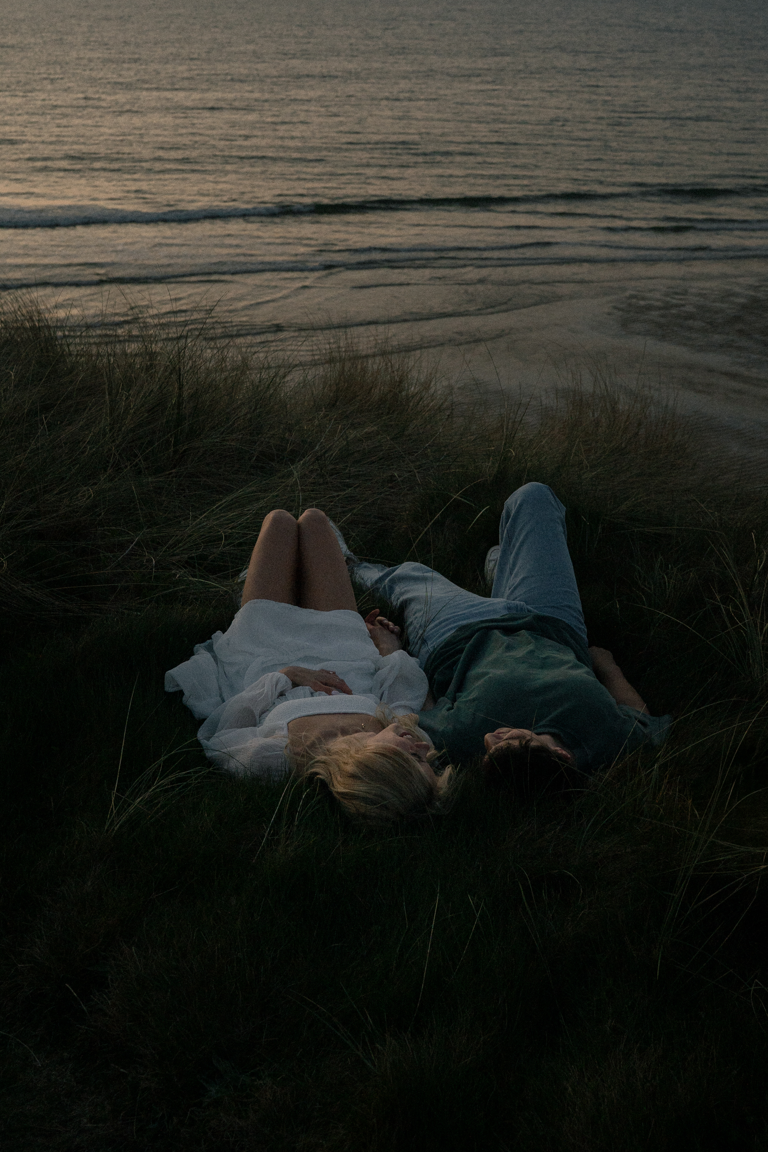 Reuben and Vanessa lying in the dunes near the sea
